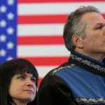 Reuters File image of Governor Mike Dunleavy standing in front of a US flag at an event
