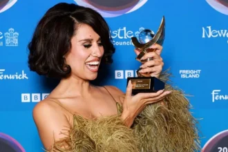 Getty Images Raye holds up her Mercury Prize