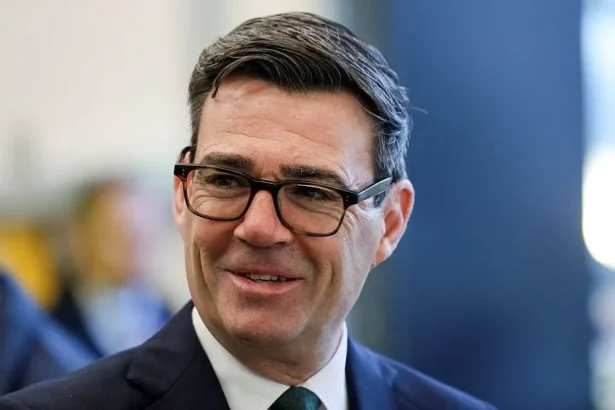 Getty Images Prime Minister Andy Burnham smiles as he looks to the side of the camera, wearing a suit.