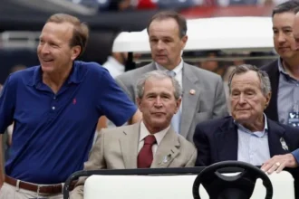 Getty Images From left: Neil Bush, George W Bush, and George HW Bush. They're sitting in a golf cart and surrounded by security and aides