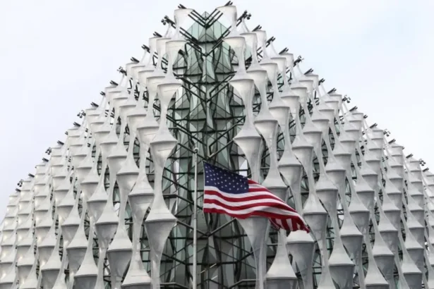PA Images The exterior of the US Embassy in London with an American flag flying in front of the nearest corner, in the centre of the image.