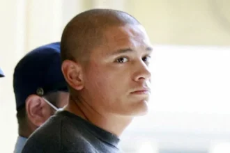 Reuters Devin Jacob Ballard, who has a shaved head and blue jumper, leaves a police station to be sent to prosecutors over the killing of a Japanese woman.