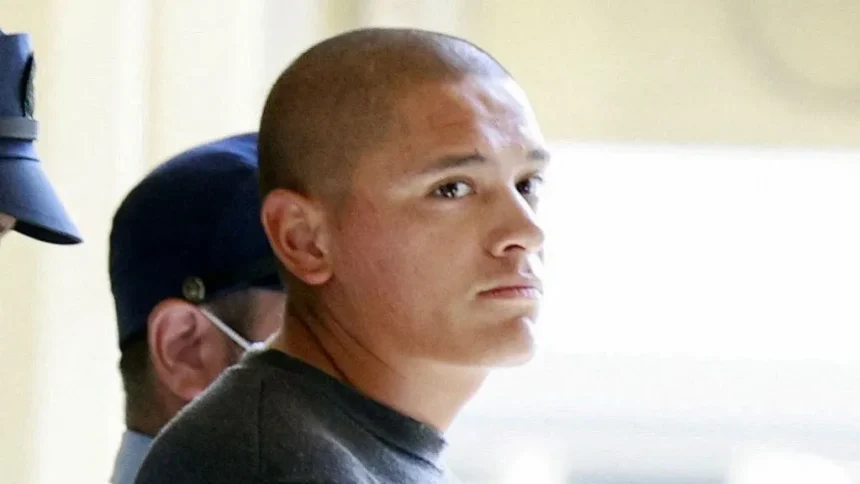 Reuters Devin Jacob Ballard, who has a shaved head and blue jumper, leaves a police station to be sent to prosecutors over the killing of a Japanese woman.