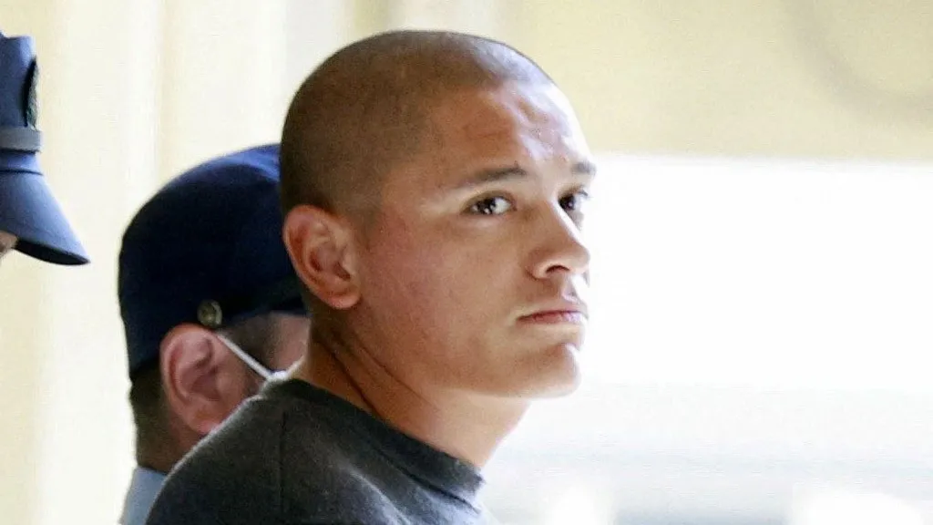 Reuters Devin Jacob Ballard, who has a shaved head and blue jumper, leaves a police station to be sent to prosecutors over the killing of a Japanese woman.