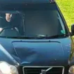 GMP CCTV image showing the front of a dark-coloured Volvo XC90 on a narrow road, with Simon Richardson visible through the windscreen in the driver's seat.