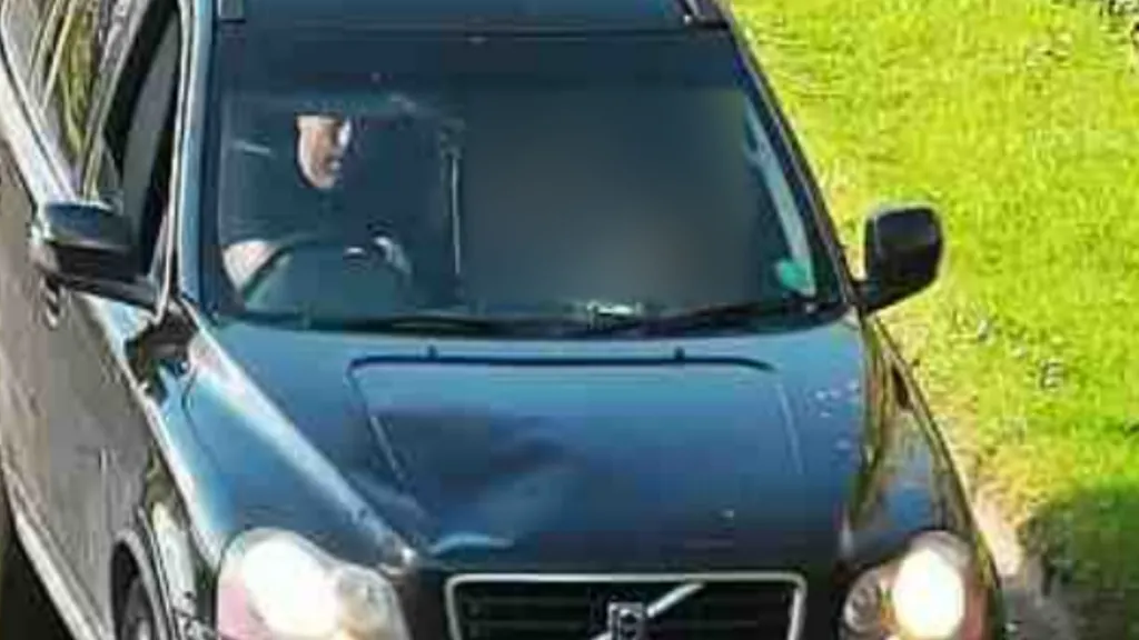 GMP CCTV image showing the front of a dark-coloured Volvo XC90 on a narrow road, with Simon Richardson visible through the windscreen in the driver's seat.