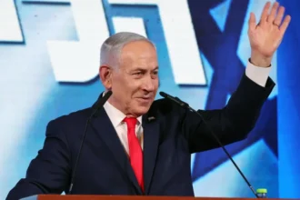 EPA Israeli Prime Minister Benjamin Netanyahu waves while addressing supporters at his Likud party's headquarters in Jerusalem (28 October 2026)