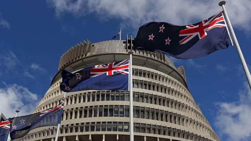Getty Images New Zealand flags flutter in the wind in clear blue skies with the parliament building in Wellington in the background