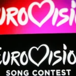 Getty Images Two Eurovision backdrops, one with white words on a pink and red background and the other with white words on a black background in the foreground.