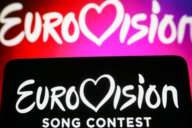Getty Images Two Eurovision backdrops, one with white words on a pink and red background and the other with white words on a black background in the foreground.
