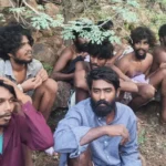 Tamil Nadu Police Eight men, appearing to be in their 20s, are sitting in a forest area after escaping a prison. Many of them are shirtless.
