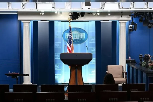 Getty Images The White House press briefing room. A podium stands against a blue backdrop bearing the White House logo. An American flag is positioned behind the podium.