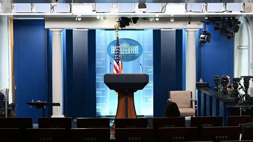 Getty Images The White House press briefing room. A podium stands against a blue backdrop bearing the White House logo. An American flag is positioned behind the podium.
