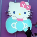 Getty Images Three women walk past a big glowing Hello Kitty signage on a purple store wall in Shanghai, China