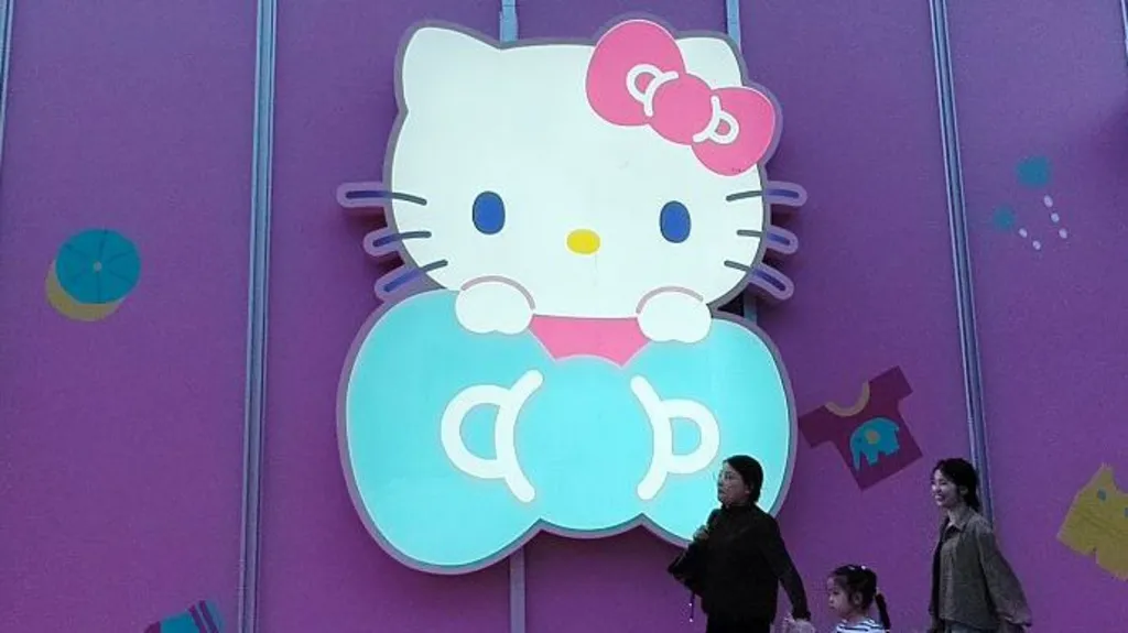Getty Images Three women walk past a big glowing Hello Kitty signage on a purple store wall in Shanghai, China