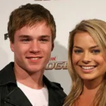Getty A young man with short brown hair and a woman with long blonde hair smile at the camera