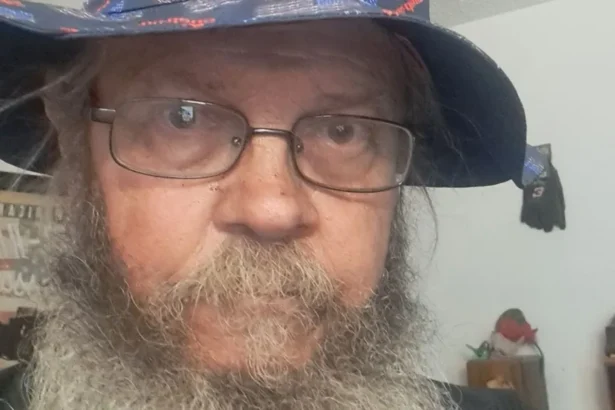 Geno Stecks Geno Stecks, 66, stares through eyeglasses at the camera, sporting a bushy beard, mustache and goatee under a floppy red-white-and-blue hat, a poster for an antique car visible in the background
