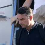 Getty Images Bolsonaro in a dark shirt carrying a backpack as he leaves a plane