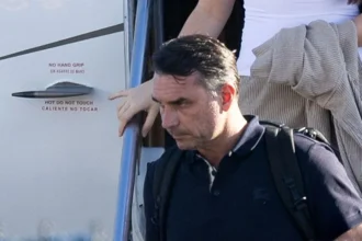 Getty Images Bolsonaro in a dark shirt carrying a backpack as he leaves a plane
