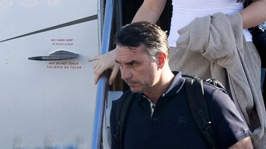 Getty Images Bolsonaro in a dark shirt carrying a backpack as he leaves a plane