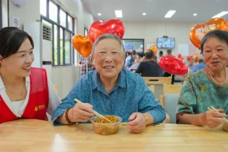 VCG via Getty Images Elderly residents taste longevity noodles while volunteers accompany them at a community care center during the Double Ninth Festival, also known as Chongyang Festival, on October 18, 2026 in Huzhou, Zhejiang Province of China.