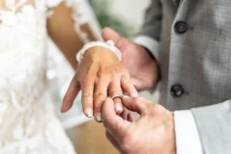 Getty Images A man puts a ring on a bride's finger