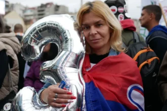 Guy Delauney/BBC A supporter with the figure 3 which represents the electoral list "Student List - Students Win" attends a final campaign rally in Belgrade, Serbia, October 22, 2026.