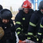 State Emergency Service Of Ukraine A group of men carry an injured person, who is out of shot, from a railway station after a strike in Dnipro.