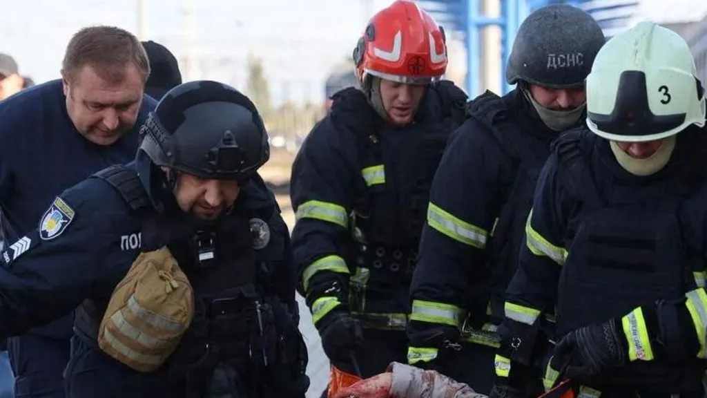 c8559bf0-d389-11f1-b5f4-fd541fd21001-jpg State Emergency Service Of Ukraine A group of men carry an injured person, who is out of shot, from a railway station after a strike in Dnipro.
