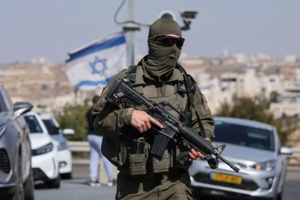 Reuters A masked Israeli soldier stands holding a gun