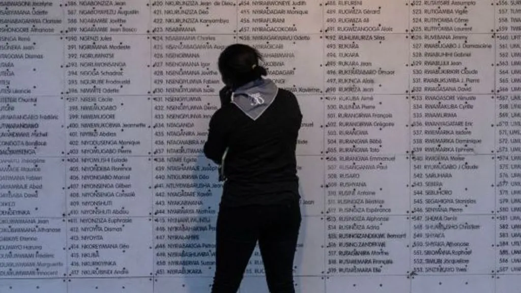 da70f3f0-d386-11f1-b5f4-fd541fd21001-jpg AFP via Getty Images A woman stands in front of list of names of people killed during the 1994 Rwanda genocide