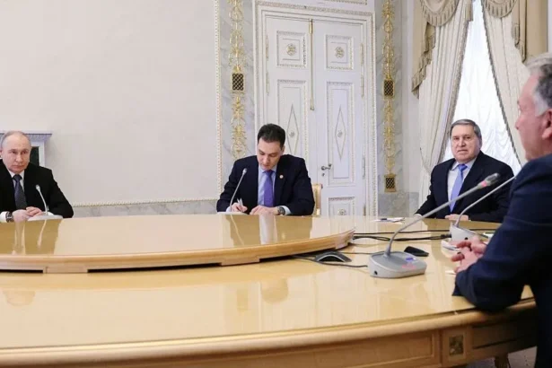 Getty Images Vladimir Putin (L) sits at a large table with foreign policy aide Yuri Ushakov (second right), Steve Witkoff (R) and one other man