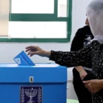 Reuters A woman wearing a headscarf puts a ballot paper in a ballot box in Israel's general election (27/1026)/