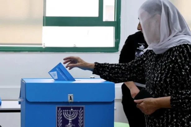 Reuters A woman wearing a headscarf puts a ballot paper in a ballot box in Israel's general election (27/1026)/