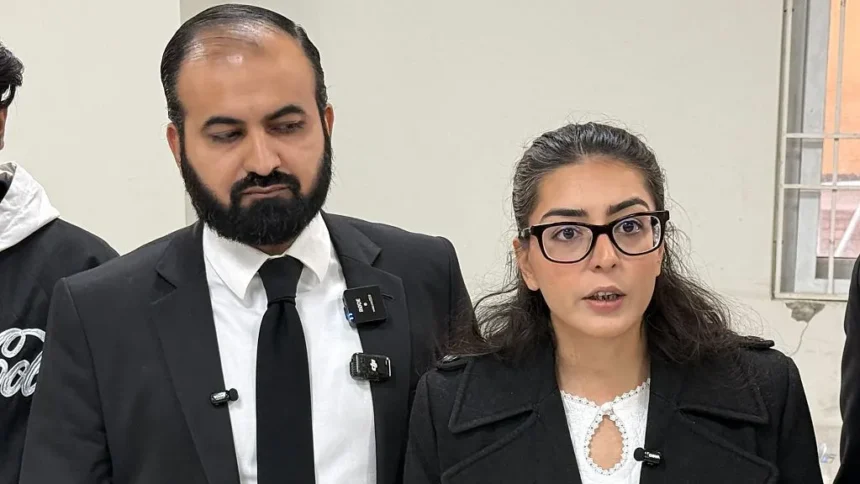 Getty Images A man with a beard in a black suit and tie, standing next to a woman in a black coat and glasses