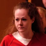 Reuters Christa Pike, a woman with red hair wears a white top with a red top on top