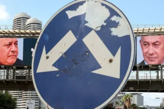 AFP via Getty Images A street sign points at billboards for Eisenkot and Netanyahu.