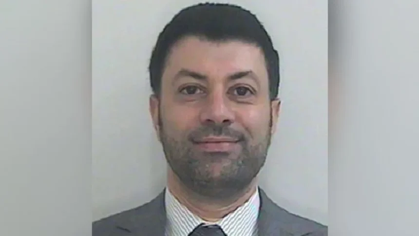 HMRC Image shows a Passport-style photo of Arif Patel, who has short dark hair, a short dark beard, and is wearing a grey suit with a grey and white striped shirt and grey tie.