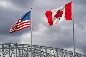Getty Images The US and Canada flags flutter next to the Blue Water Bridge border crossing in Point Edward, Ontario, on 24 October 2025.