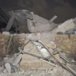 Anadolu via Getty Images Rubble sits atop a small brick wall and six stairs.
