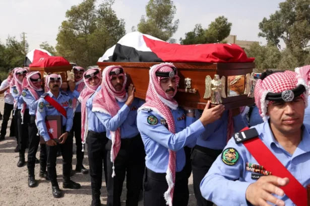 Reuters Jordanian security personnel carry the coffins of victims of a church shooting in Karak, Jordan (25 October 2026)