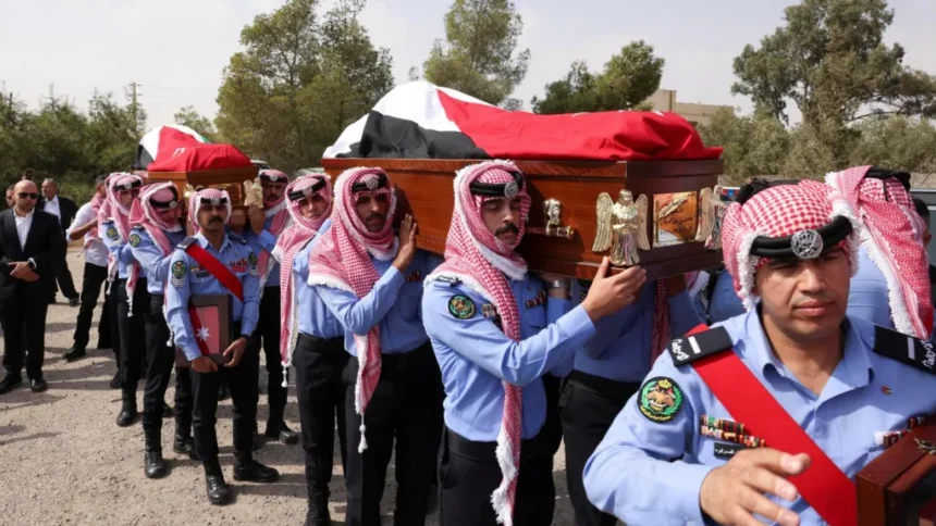 Reuters Jordanian security personnel carry the coffins of victims of a church shooting in Karak, Jordan (25 October 2026)