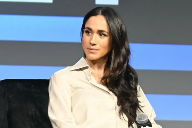 Getty Images Meghan looks to the left of frame while sat onstage with blue and black background behind her, at SXSW in Austin in 2024.